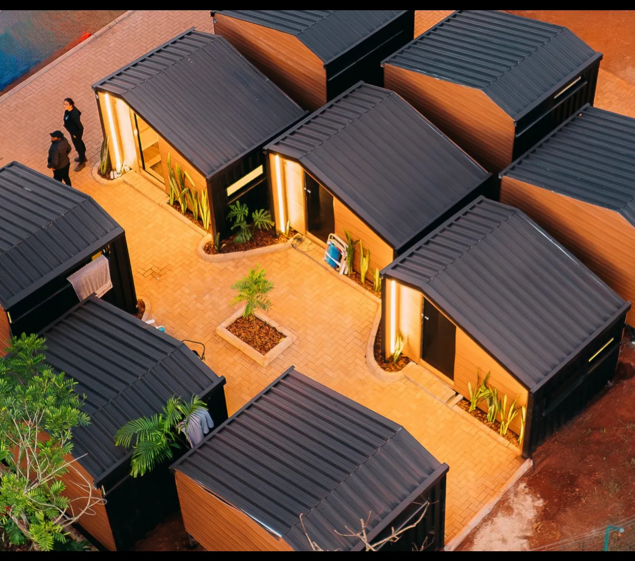 Vista aérea das cabanas premium do STL Valley, dispostas ao redor de um pátio iluminado
